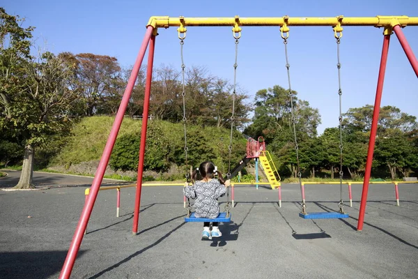 Japanese girl on the swing　(appearance from behind) (5 years old) — Stock Photo, Image